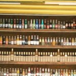 Diverse collection of soda and beverage bottles neatly arranged on wooden shelves.