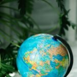 Vibrant globe on a stand surrounded by lush green plants.